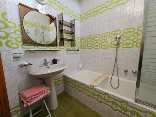 a bathroom with a sink and a bath tub and a mirror at Villa di design nelle colline della Valsesia in Ghemme