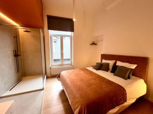 - une chambre avec un grand lit et une fenêtre dans l'établissement L'escapade chic - Cathédrale, Saint Lambert, à Liège