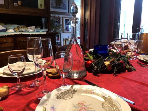 a table with a red table cloth with wine glasses at Villa di design nelle colline della Valsesia in Ghemme