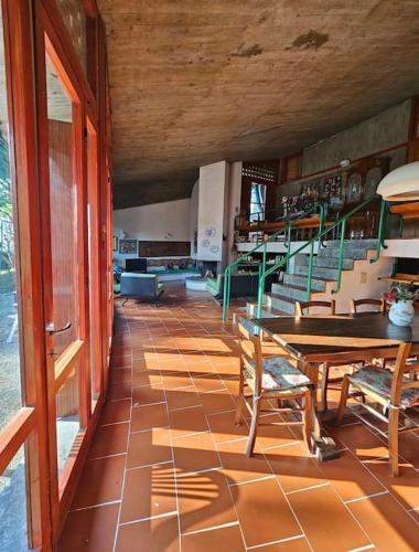a room with a table and chairs and stairs at Villa di design nelle colline della Valsesia in Ghemme