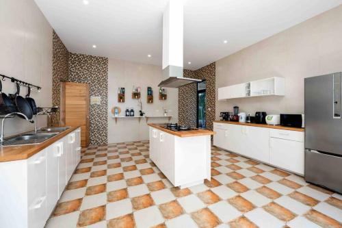 a large kitchen with white cabinets and a tiled floor at MQ女王海滨6 bedroom 别墅 免费婴儿床海景日出烧烤家庭适用 in Koh Samui