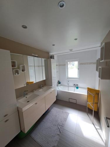 uma casa de banho com 2 lavatórios e uma banheira em Sweet home em Tervuren