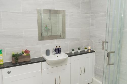 a white bathroom with a sink and a mirror at Spacious, Contractors, Long Term Discounts in Birmingham
