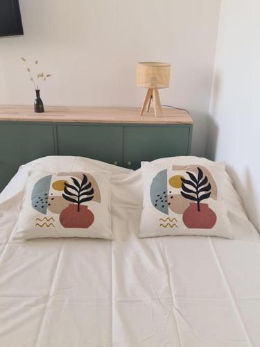 un lit avec deux oreillers dessus dans l'établissement Carnon - Magnifique T2 - Plage à 2 min à pied, à Mauguio