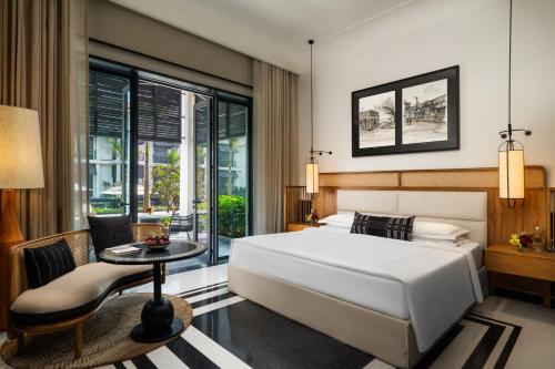 a bedroom with a large white bed and a table at Taj Taal Kutir in Kolkata
