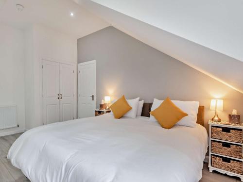 1 dormitorio con 1 cama blanca grande con almohadas amarillas en 4 Bed in Branston 94516 en Branston