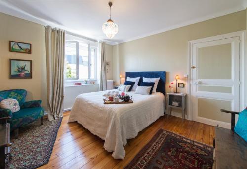 1 dormitorio con 1 cama y 1 silla azul en La Mancelle - Chambre d'hôtes en Le Mans
