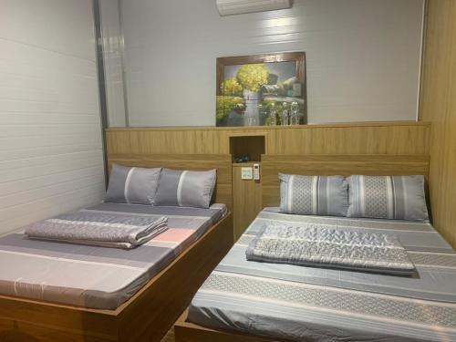 two beds sitting next to each other in a room at Homestay Chân Quê in Bao Loc