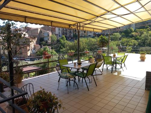 a patio with tables and chairs on a balcony at B&B Villa Letizia in Castelbuono