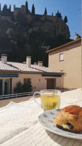 une assiette avec une boisson et une pâtisserie sur une table dans l'établissement Appartement bord de plage, à Cassis