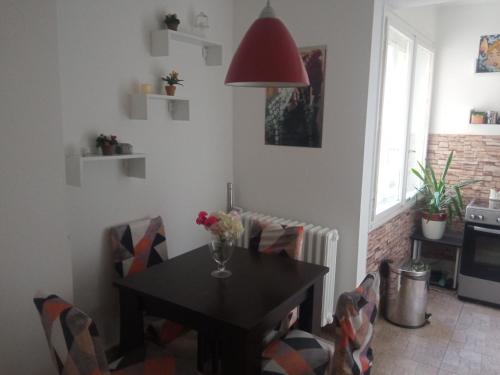 Una mesa de comedor con un jarrón de flores encima. en Liman1, en Novi Sad