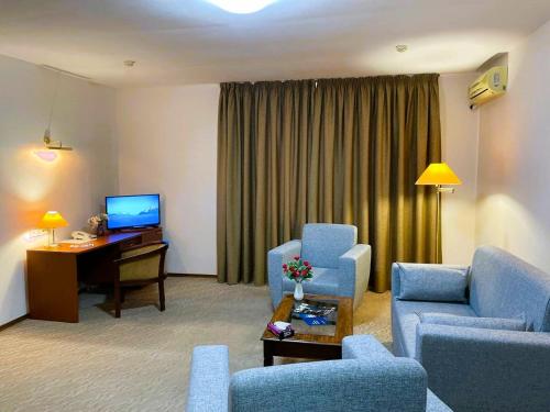 a living room with two chairs and a desk in a hotel room at Tengri Hotel in Atyrau