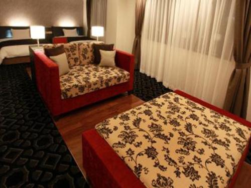 a living room with a couch and a chair at Chisun Grand Takayama in Takayama