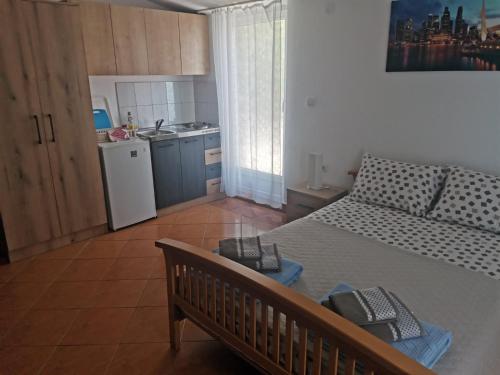 a small bedroom with a bed and a kitchen at Studios Kalina in Budva
