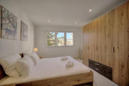 une chambre avec un lit avec des oreillers blancs et une fenêtre dans l'établissement Immogroom - AC - 1 bedroom - Balcony - Renovated, à Cannes