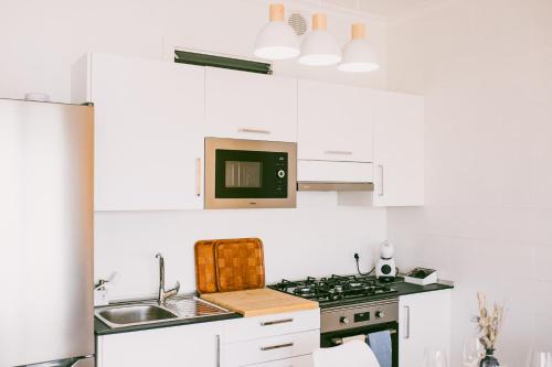 a white kitchen with a stove and a microwave at VV La Niña - Salinetas -Telde in Las Palmas de Gran Canaria
