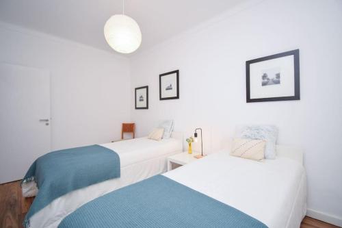 2 Betten in einem Zimmer mit weißen Wänden in der Unterkunft Scarlatti Garden House - Ap. Charming with Garden in Queluz
