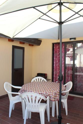 a white table with white chairs and an umbrella at Donna Lucia in Giardini Naxos
