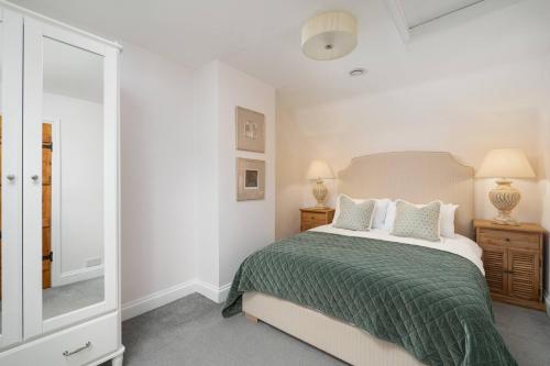 een witte slaapkamer met een bed en een spiegel bij Charming 4 Bed Cottage in Herts Countryside - Pass the Keys 