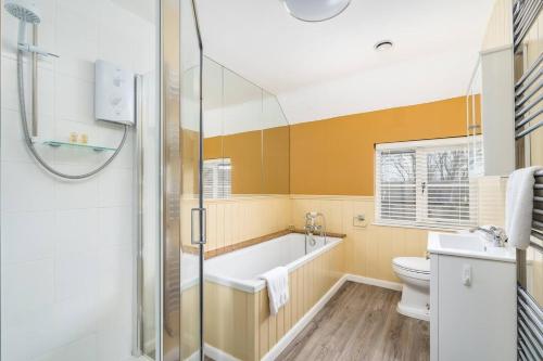 een badkamer met een bad, een toilet en een douche bij Charming 4 Bed Cottage in Herts Countryside - Pass the Keys 