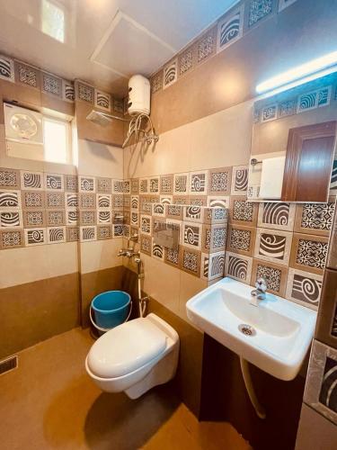 a bathroom with a toilet and a sink at Amalas Lodge in Trivandrum