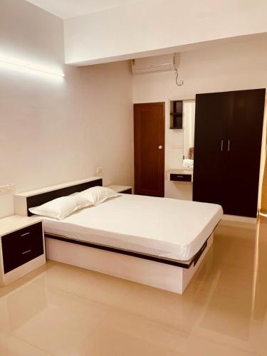 ein Schlafzimmer mit einem großen weißen Bett in einem Zimmer in der Unterkunft Amalas Lodge in Thiruvananthapuram