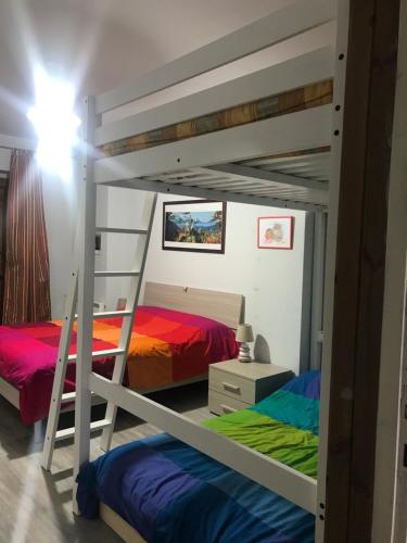 a bedroom with two bunk beds and a ladder at Pian Munè appartamento (San Lorenzo) in Paesana