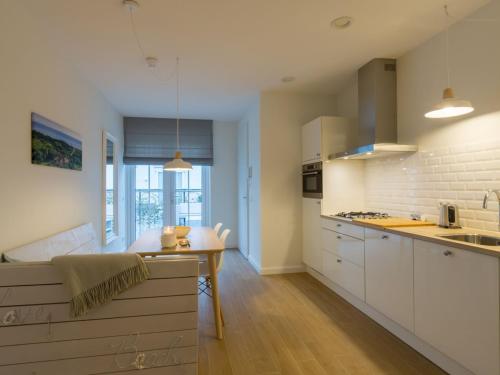 een keuken met witte kasten en een aanrecht bij Elegant Apartment in Koudekerke with Gas Fireplace in Koudekerke