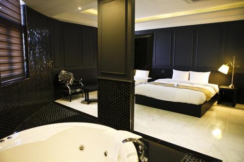 a bathroom with a tub and a bed and a bath tub at Hotel Doma Myeongdong in Seoul