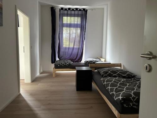 a bedroom with a bed and a window with purple curtains at Sanierter Altbau - 5 Bett in Wuppertal