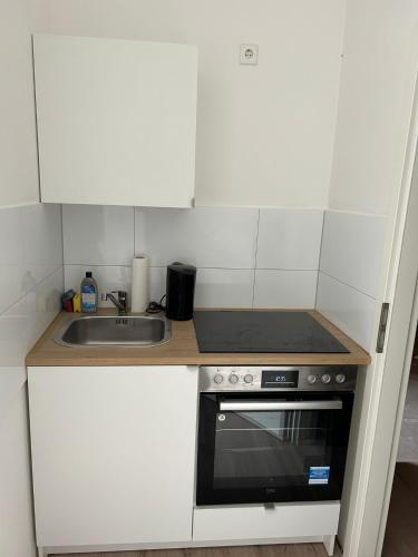a kitchen with a sink and a stove at Sanierter Altbau - 5 Bett in Wuppertal