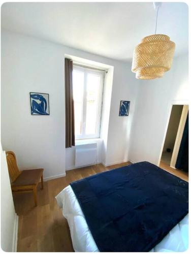 Un dormitorio con una cama azul y una ventana en L'écrin, en Angers