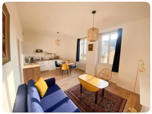 een woonkamer met een blauwe bank en een tafel bij L'écrin in Angers