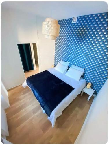 - une chambre dotée d'un lit avec un mur bleu dans l'établissement L'écrin, à Angers