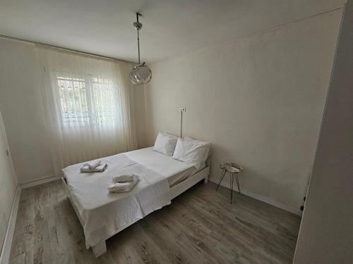 Schlafzimmer mit einem Bett mit weißer Bettwäsche und einem Fenster in der Unterkunft Kekik Azure Homes Ölüdeniz in Fethiye