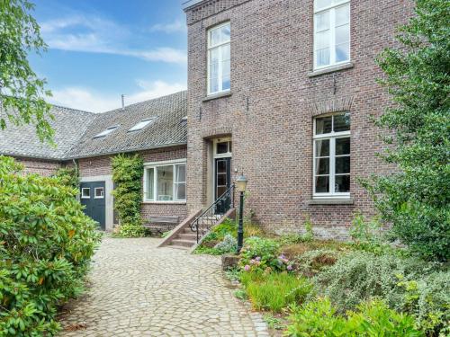 uma antiga casa de tijolos com uma entrada de pedra em Spacious Mansion in Swolgen with Garden em Swolgen