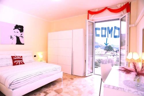 a bedroom with a white bed and a large window at Elizabeth House in Como