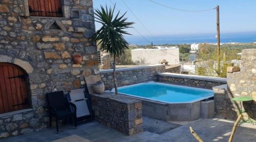 una casa de piedra con un patio con piscina en Villa Sabrina, en Milatos