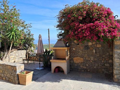 una pared de piedra con una casa de pájaros y flores en Villa Sabrina, en Milatos