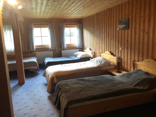 Cette chambre dispose de 3 lits et de fenêtres. dans l'établissement The Pirklalm, à Pruggern