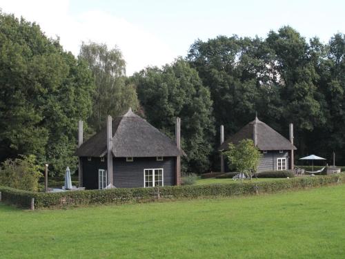 zwei kleine Häuser mit Strohdächern auf einem Feld in der Unterkunft Cozy house with or without hot tub near a river in Notter