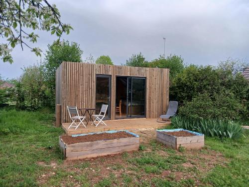 une petite maison en bois avec deux chaises et une table dans l'établissement studio de jardin, à Domblans
