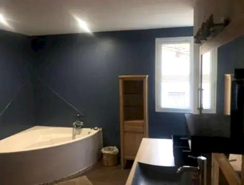 a bathroom with a bath tub and a window at Villa de 3 chambres avec piscine privee jardin clos et wifi a Gaillac in Gaillac