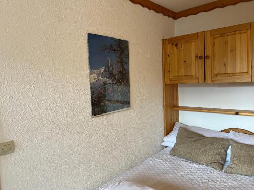 a bedroom with a bed and a picture on the wall at La Villaret in Les Menuires