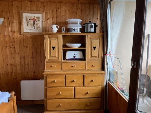 - une commode en bois avec un four micro-ondes dans l'établissement La Villaret, aux Menuires