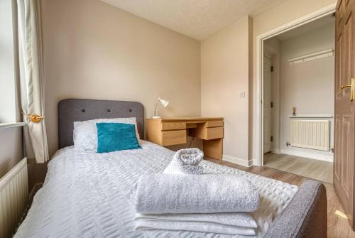 a bedroom with a bed with a blue pillow and a desk at Stylish 2 Bed Flat Close To Nec Bhx in Solihull
