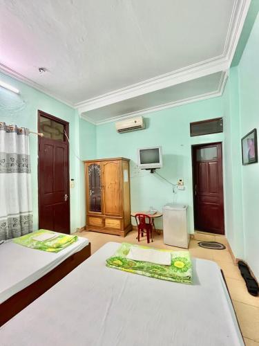 a room with two beds and a tv on the wall at Thanh Lam Hotel in Sầm Sơn
