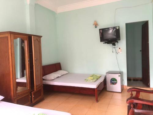 a small room with a bed and a tv at Thanh Lam Hotel in Sầm Sơn