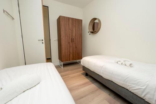 a bedroom with two beds and a wooden cabinet at Welcome in - Appartement - Paviljoenwei 4 - Sneek 'Havenzicht' in Offingawier