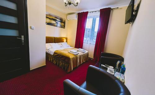 a hotel room with a bed and two chairs at Rezydencja Królewska in Sandomierz